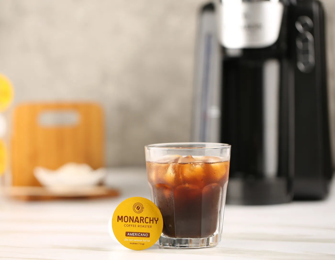 Es kopi dengan kapsul Monarchy dan mesin kopi